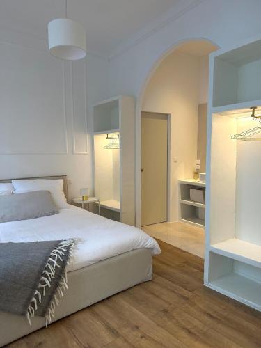 une chambre avec un grand lit blanc et une salle de bain dans l'établissement Appartement Nemausus XIX, à Nîmes