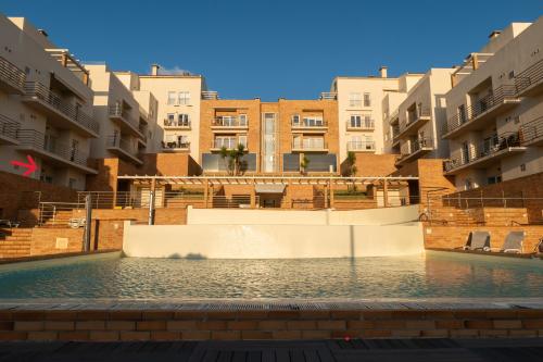 a swimming pool in the middle of some apartment buildings at Pé na Praia da Foz in Foz do Arelho
