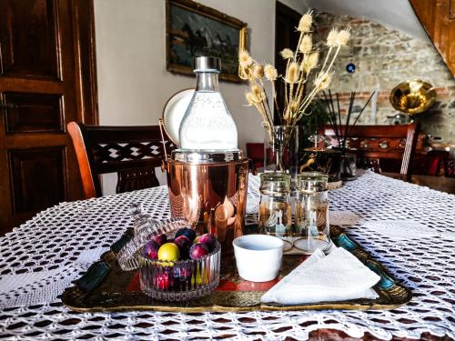 a table with a bottle and a basket of fruit at Domus Hotel in Korçë