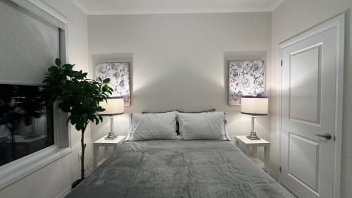 a bedroom with a bed with two lamps and a plant at Ivylea Elegant Luxury Estate Richmond Hill in Richmond Hill