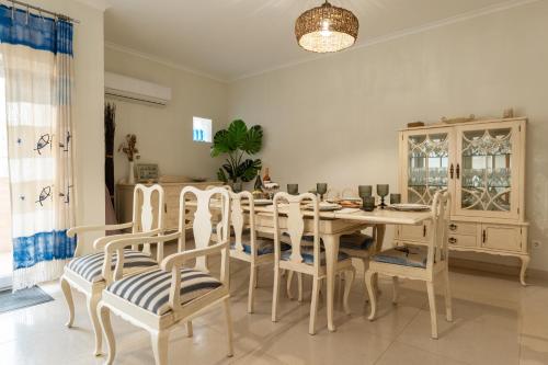 a dining room with a wooden table and chairs at Pé na Praia da Foz in Foz do Arelho