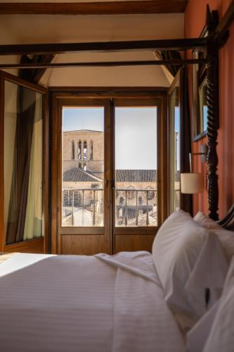 a bedroom with a bed and a view of a building at Hotel Convento Del Giraldo in Cuenca