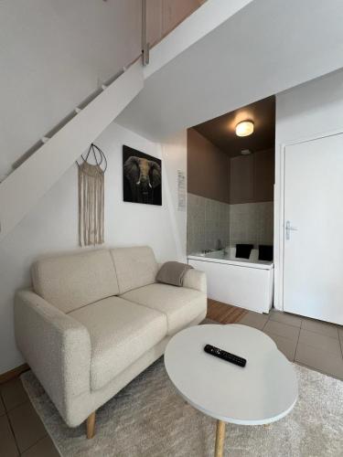 un salon avec un canapé et une table dans l'établissement Joli petit duplex avec jacuzzi, à Ermont