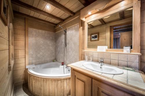 a bathroom with a tub and a sink at Hôtel Christiania in Val-d'Isère