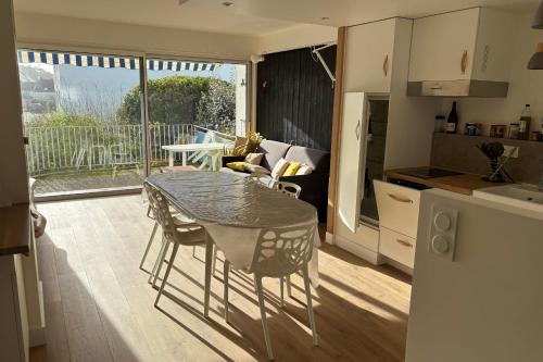 une cuisine avec une table et des chaises dans une pièce dans l'établissement Appartement Kerabus proche plage, à Quiberon
