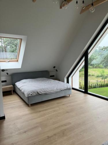 a bedroom with a bed and large windows at Wisełkowe Zacisze in Wisełka
