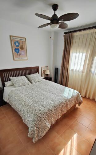 a bedroom with a bed and a ceiling fan at Apartamento ideal a un paso de la playa in Playas de Vera