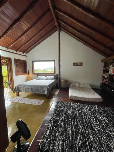 a bedroom with two beds and a large rug at Casa do Noé in Paraty