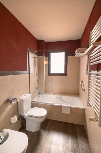a bathroom with a toilet and a tub and a sink at Hotel Convento Del Giraldo in Cuenca