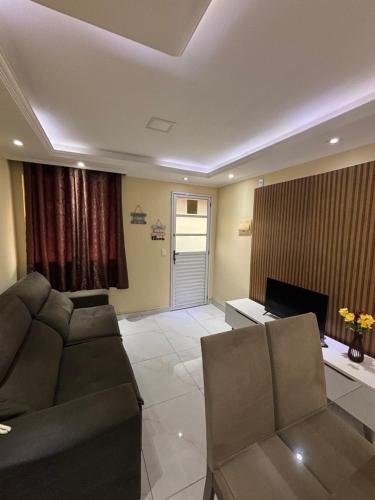 a living room with a couch and a television at Aconchego em Campo Grande - Guaratiba in Rio de Janeiro
