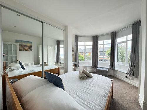 タインマスにあるLongsands House, Tynemouth Victorian Residenceのベッド2台と大きな鏡のある寝室