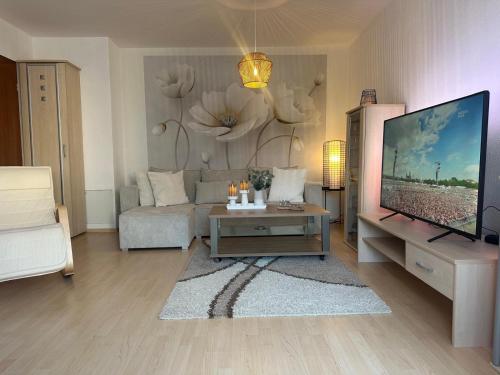 a living room with a couch and a television at La Pura Vida in Bühlertann