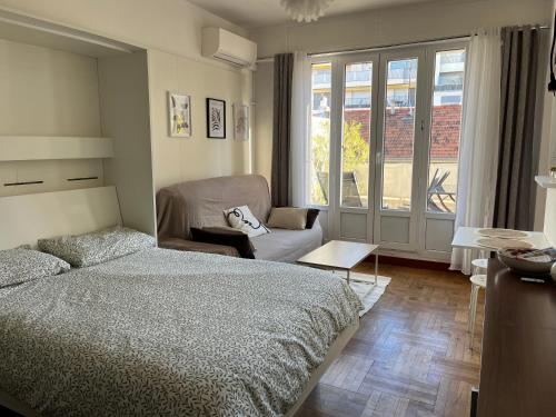 une chambre avec un lit, une chaise et une fenêtre dans l'établissement Studio with large terrace sea view 4th floor, à Nice