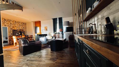 un salon avec des canapés, une cuisine et un salon dans l'établissement Ancienne école proche du Puy du Fou, à Montigné-sur-Moine