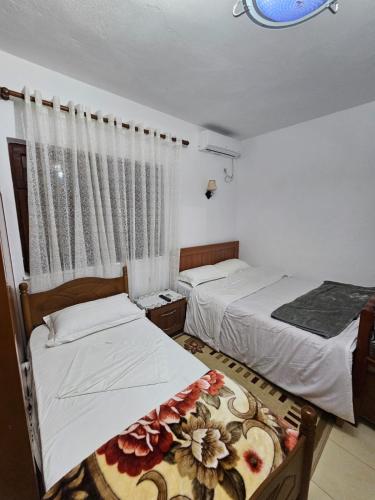 a bedroom with two beds and a window at Bujtina Polimen in Përmet