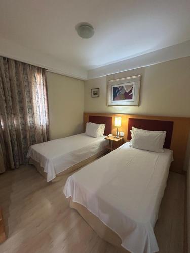 a hotel room with two beds and a window at Hotel Biena Sena Madureira PqIbirapuera Com Garagem 907 in Sao Paulo