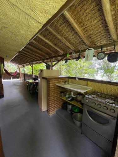 a kitchen with a counter and a sink and a stove at Suítes Cachadaço Beach in Paraty