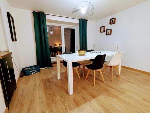 une salle à manger avec une table et des chaises blanches dans l'établissement Appart COSY 2 ch avec Terrasse privé & BBQ, à Charmes