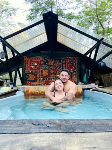 a man and a woman in a swimming pool at La Colmena eco lodge in Ensenada