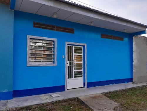 a blue building with a door and a window at Hogar y naturaleza in Iquitos