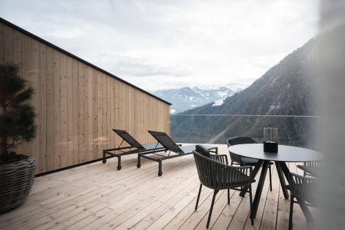 a balcony with chairs and a table with a view at apartments arduus - high living in Naturno