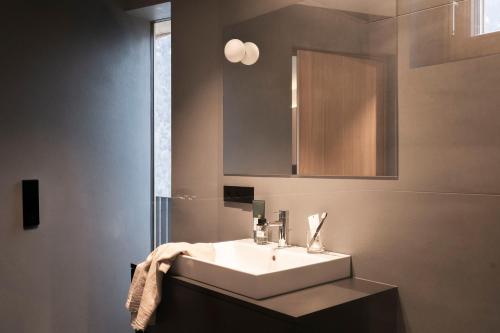 a bathroom with a white sink and a mirror at apartments arduus - high living in Naturno