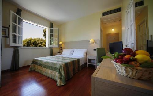 a hotel room with a bed and a basket of fruit at Hotel Borgo Verde in Catania