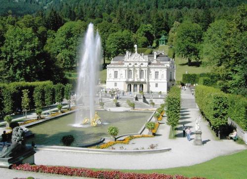 a large mansion with a fountain in front of it at Ferienwohnung Farchanter Alm mit Schlafzimmer, Wohnzimmer und Schlafnische in Farchant