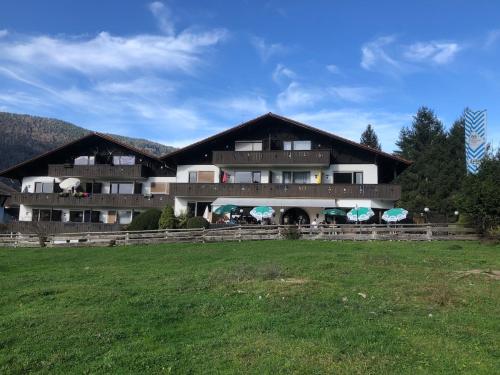 a large building with a grass field in front of it at Ferienwohnung Farchanter Alm mit Schlafzimmer, Wohnzimmer und Schlafnische in Farchant