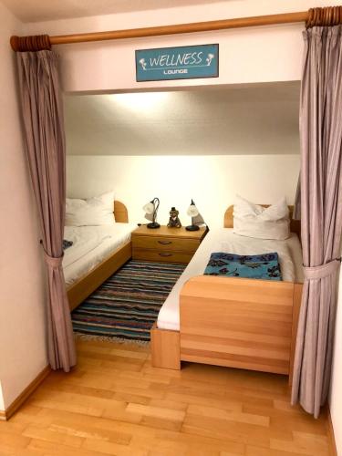 a bedroom with two beds and a sign that reads wellness ranch at Ferienwohnung Farchanter Alm mit Schlafzimmer, Wohnzimmer und Schlafnische in Farchant