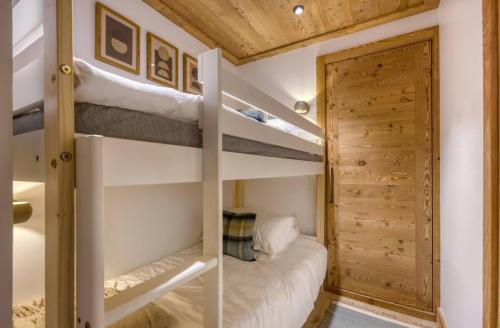 - une chambre avec 2 lits superposés et un placard dans l'établissement Ski in Ski out serviced apartment in Megeve, à Megève