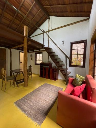 a living room with a red couch and a staircase at Casa do Benedicto in Paraty
