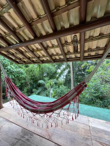 a hammock hanging under a roof on a patio at Casa do Benedicto in Paraty