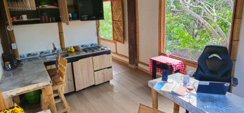 a kitchen with a counter and a table with chairs at Bio Coliving Tayrona in Santa Marta