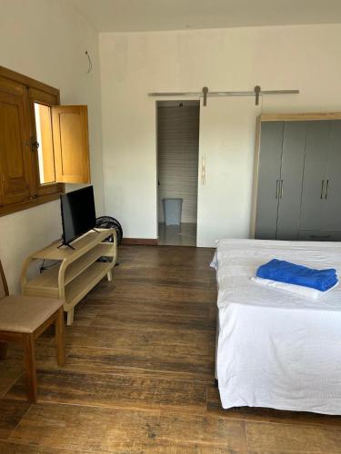 a bedroom with a bed and a table and a chair at Capri in Cananéia
