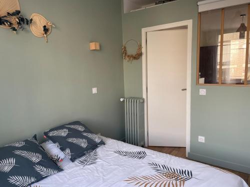 une chambre avec un lit avec deux oreillers dessus dans l'établissement Appartment T2 Asnières Gare, à Asnières-sur-Seine