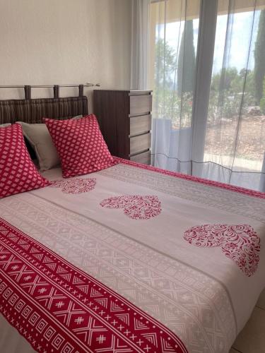- une chambre avec un lit doté de draps rouges et blancs et une fenêtre dans l'établissement Villa T2 Domaine de Manon, à Signes