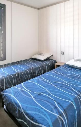 deux lits côte à côte dans une pièce dans l'établissement Chalet enchanteur à Arzal avec vue sur lac et piscine partagée, à Arzal