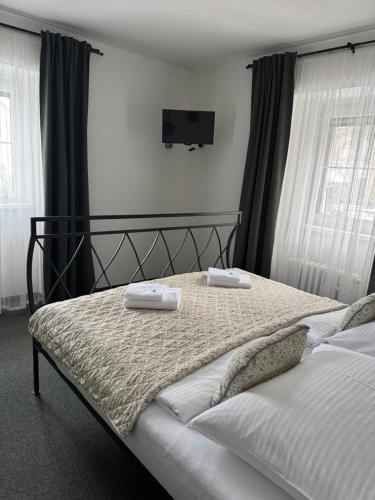 a bedroom with a bed with two towels on it at Pension U Draka in Karlovy Vary