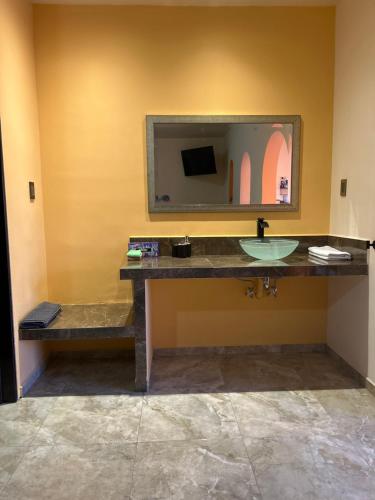 a bathroom with a sink and a mirror at Tres Iguanas Apart Hotel - New, cozy & spacious flats, short walk to beach in Loreto