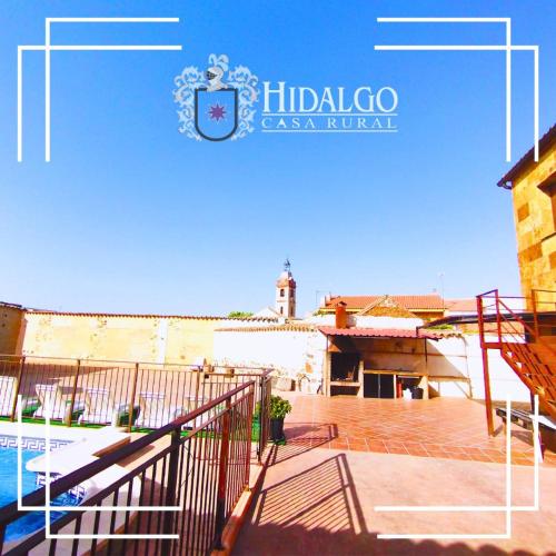 a sign for a villa with a pool and a building at Casa Rural Hidalgo in Ciudad Real