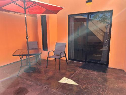 a room with a table and a chair and an umbrella at Tres Iguanas Apart Hotel - New, cozy & spacious flats, short walk to beach in Loreto