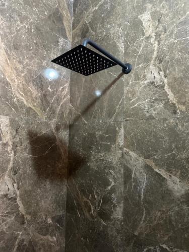 a stone shower with a black grate on it at Tres Iguanas Apart Hotel - New, cozy & spacious flats, short walk to beach in Loreto