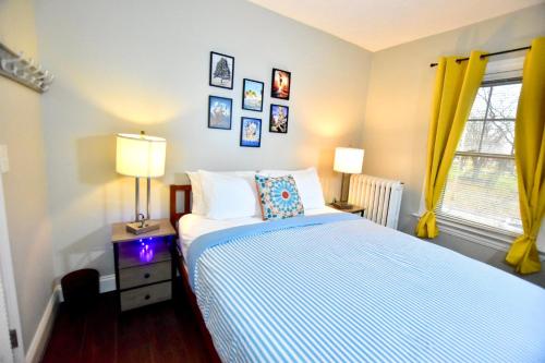 a bedroom with a bed and two lamps and a window at Lake Avenue Apartment in Cleveland