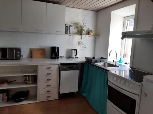 a kitchen with a sink and a stove top oven at Hyggeligt hus på landet in Ansager