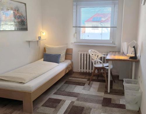 a small bedroom with a bed and a desk and a table at 4-Zimmer Haus in Leipzig in Leipzig