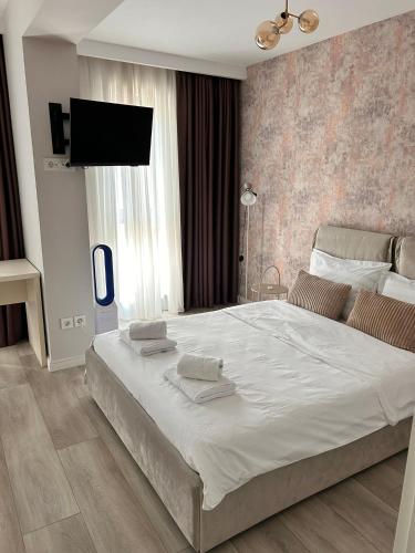 a bedroom with a large bed with a flat screen tv at Elegance in Bucharest