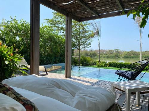 a patio with a bed and a swimming pool at Hermosa casa en Karibana Ctg in Cartagena de Indias