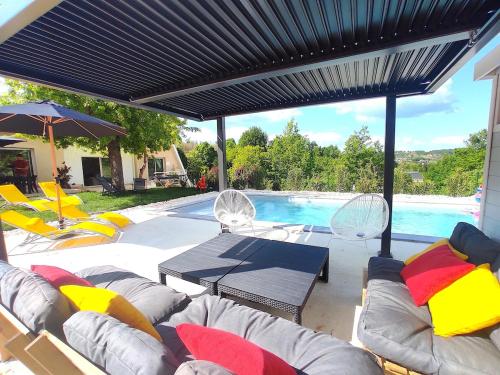 une terrasse avec des chaises, une table et une piscine dans l'établissement La Villa d Elsa 10-12 pers piscine chauffée 500m du centre ville, à Sarlat-la-Canéda