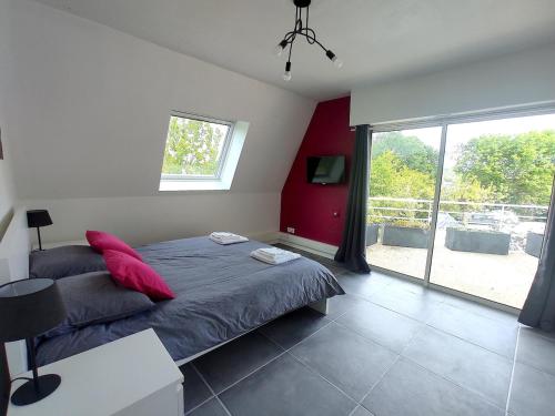 une chambre avec un lit avec des oreillers rouges et une fenêtre dans l'établissement La Villa d Elsa 10-12 pers piscine chauffée 500m du centre ville, à Sarlat-la-Canéda